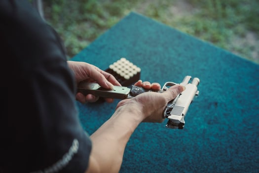 Shooter man loading In a gun magazine and black clothes prepare to shooting short gun at the shooting range. Shooting sports for meditation and self-defense, recreational activities. photo