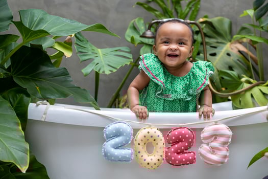African baby toddler sitting in the bathtub with 2023 happy new year sign for season celebration for happiness and kid usage photo
