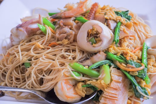 Hong Kong recipe stir-fried noodles with egg, fresh squid, shrimp, pickled squid and Hong Kong vegetables. photo