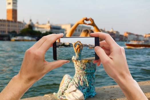 Hands capturing colorful beautiful landscape on smart phone during travels abroad photo