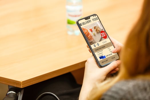 holding phone with app delivery food screen photo