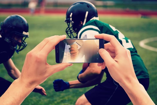 Betting man through his smart phone in at stadium photo