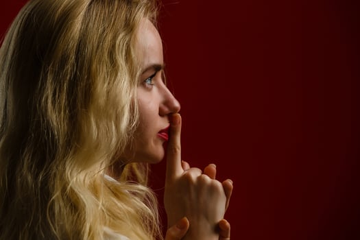 Girl shows quieter finger to mouth. Profile photo
