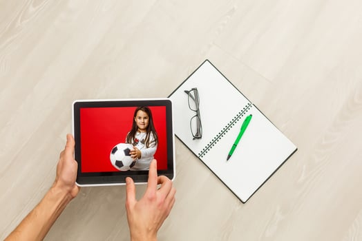 Man watching live sport stream online with mobile device. Hand holding tablet with imaginary video player and streaming service. photo