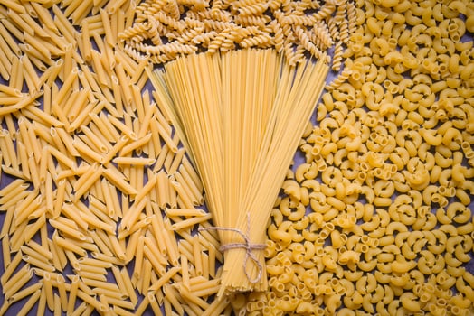 Raw pasta various kinds of uncooked pasta macaroni spaghetti and noodles on wooden, Italian food culinary concept, Collection of different raw pasta on cooking table for cooking food photo