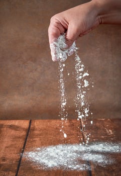 The hands of an elderly, plump woman are kneading dough on a wooden table. Preparation of dough for a festive cake, pizza photo
