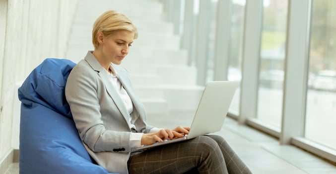 Businesswoman using laptop computer on lazy bag in the modern office photo