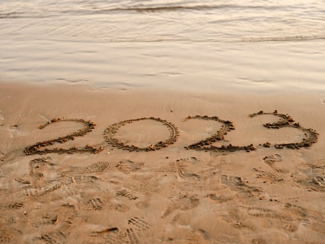 New year concept photo. Numbers 2023 handwritten in the sand surface. Soft sea wave and beach on background. photo