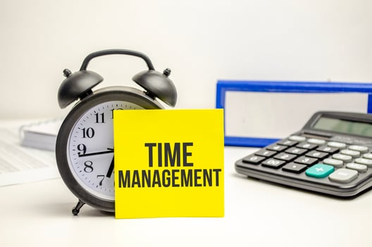 time management words on yellow sticker with clock, calculator and paper folder photo