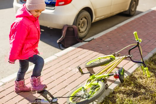 a little girl pumps up a bicycle tire. photo