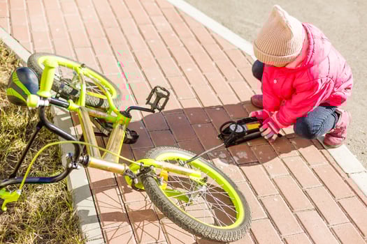 inflating a tyre of her bicycle, closeup shot photo