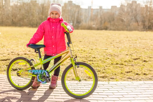 Smiling little girl on a bicycle photo