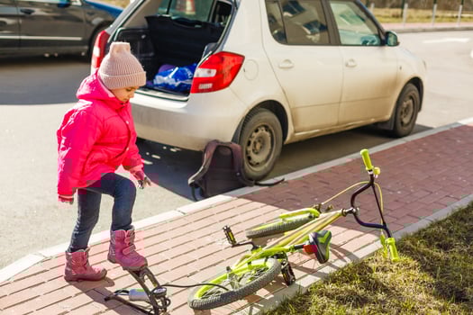 a little girl pumps up a bicycle tire photo