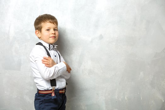 Elementary school student carrying notebooks over a gray background photo