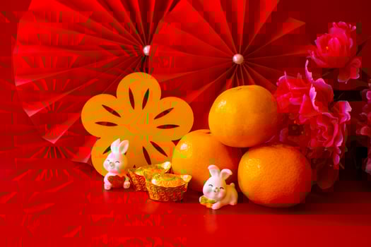 Chinese New Year of the rabbit festival concept. Mandarin orange, red envelopes, rabbit and gold ingot with red paper fans. Traditional holiday lunar New Year. Chinese character cai meaning money. photo