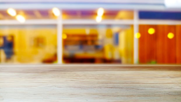 Wooden table with a blur cafe background with an aesthetic interior atmosphere photo
