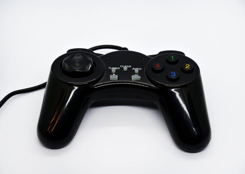 The gamepad is black and shiny on a white background. Game joystick close-up. A gamepad for a game console. photo