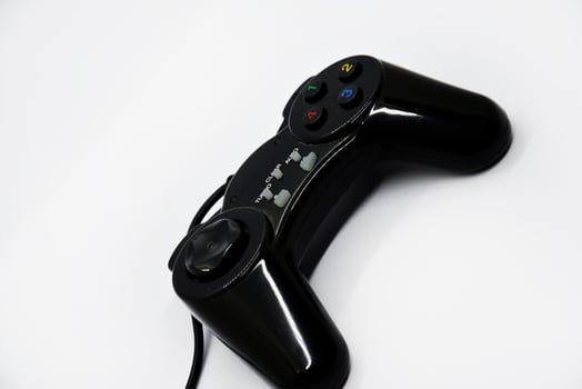 The gamepad is black and shiny on a white background. Game joystick close-up. A gamepad for a game console. photo