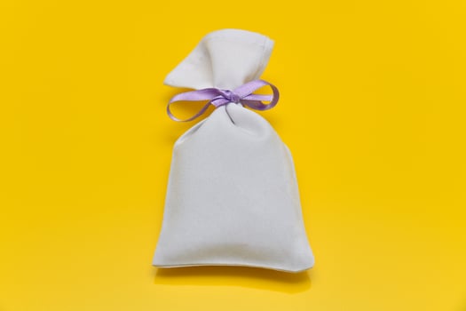 Small white sack isolated on yellow background photo