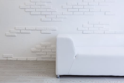 Empty waiting room with a modern gray sofa in front of the door and a clock on the wall photo
