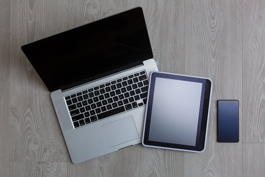 Modern laptop, mobile phone and tablet on white wooden background photo