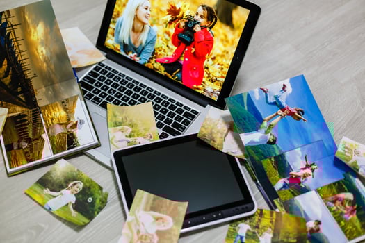 Old family photos on wooden background. Vintage pictures, notepad and modern notebook. Flat lay. Blank photo frames