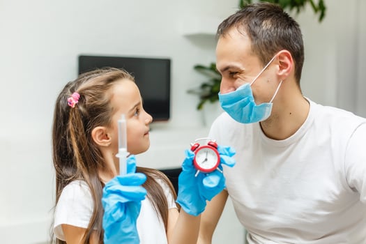 Adorable little girl and her father or doctor in medical mask by the window at home or hospital. . Quarantine. Coronavirus. Epidemic. photo