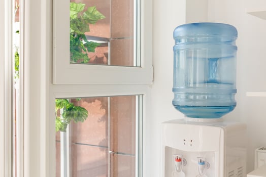 blue water gallon on electric water cooler in office area photo