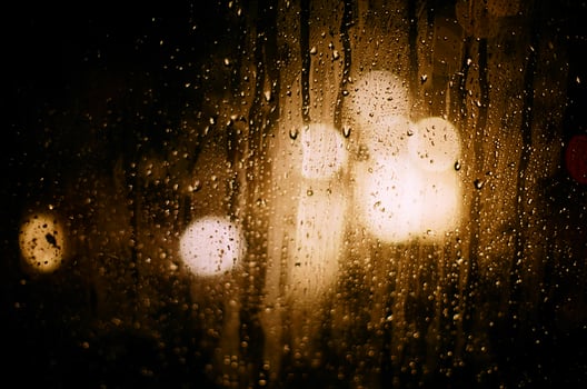 on the glass round reflections of the blurred light of car headlights during the rain. photo