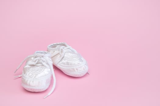 booties for a newborn on a pink background copy space photo