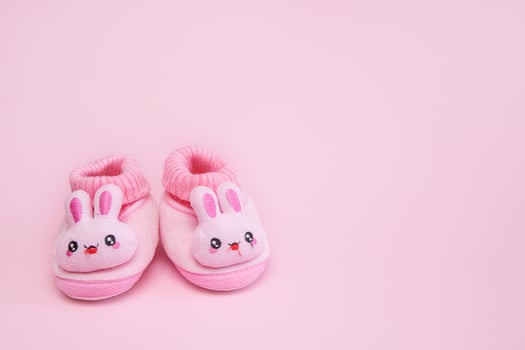 booties in the form of hares on a pink background with copy space photo