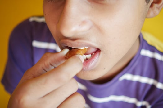 boy putting chocolate in mouth photo