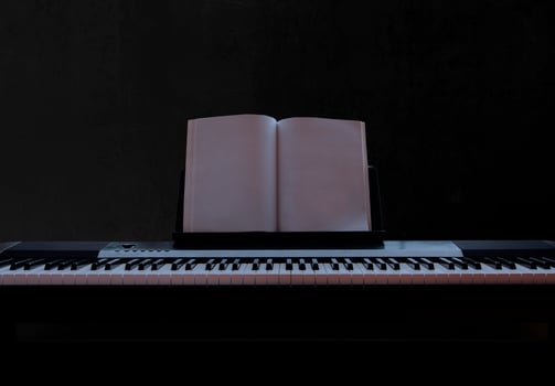 Electric piano with empty sheet music on black background, piano keyboard on dark background concept art, front view photo