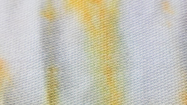 white cloth texture with yellow and blue patterns as background photo