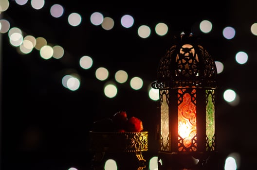 Lantern and dates fruit with bokeh light in dark background for the Muslim feast of the holy month of Ramadan Kareem. photo