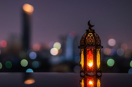 Lantern with dusk sky and city bokeh light background for the Muslim feast of the holy month of Ramadan Kareem. photo