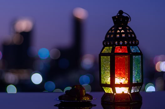 Lantern and small plate of dates fruit with night sky and city bokeh light background for the Muslim feast of the holy month of Ramadan Kareem. photo