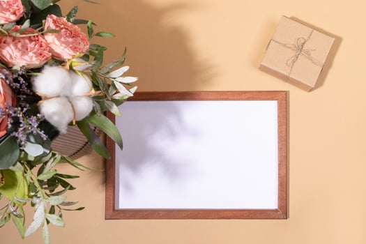 Flowers bouquet, frame with copy space, diy gift box on beige backdrop for Women's day, Valentine's day, Mother's day. photo