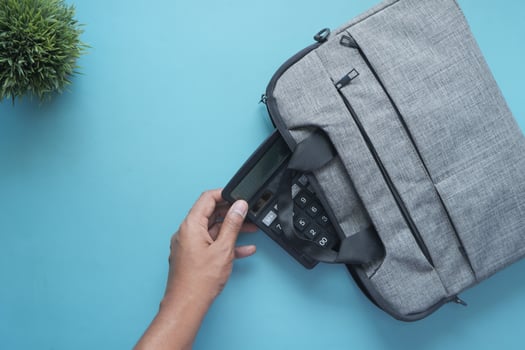 top view of young man putting office stationary in his bag photo