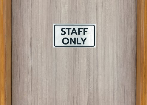 Warning sign in front of the door with a message for staff only photo