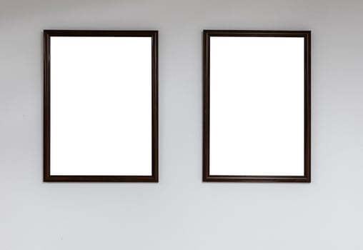 Two empty picture frames on a white wall photo