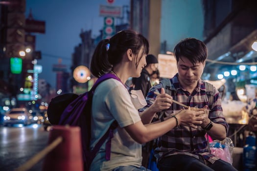 Asian couple eating in Street food Night market for tourist on chinatown at yaowarat road in bangkok photo