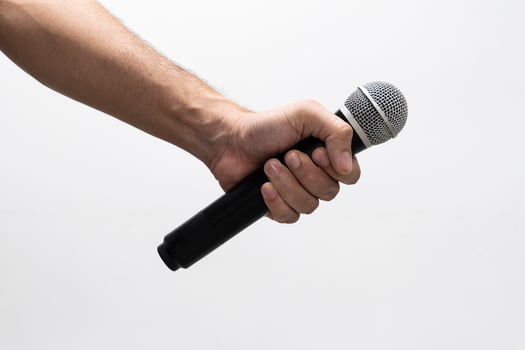 Hand holding a microphone isolated on white background photo