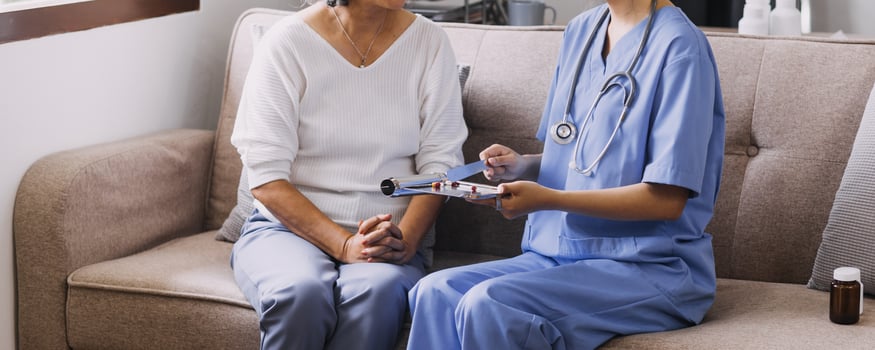 Homecare nursing service and elderly people cardiology healthcare. Close up of young hispanic female doctor nurse check mature caucasian man patient heartbeat using stethoscope during visit photo