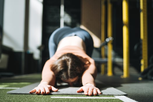 Young brunette woman doing stretching pilates, practice yoga on mat in fitness club, selective focus photo