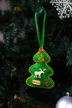 Creative diy craft hobby. Making handmade craft christmas ornaments and balls with felt spruce tree. christmas tree with colorful balls and gift boxes over white brick wall with blue and white balls photo
