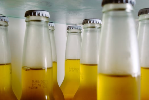Cold beer bottles, closeup, cooling glass bottles with yellow alcohol liquid in the fridge before the party. photo