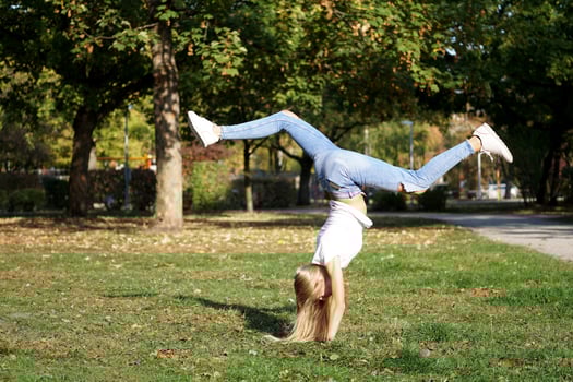 girl praticing handstand in a park photo