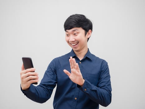 Asian man holding mobile phone video call with happy emotion and smile on white background photo