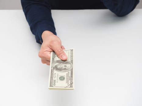 Man hand giving money dollar on the table,Earn salary concept photo